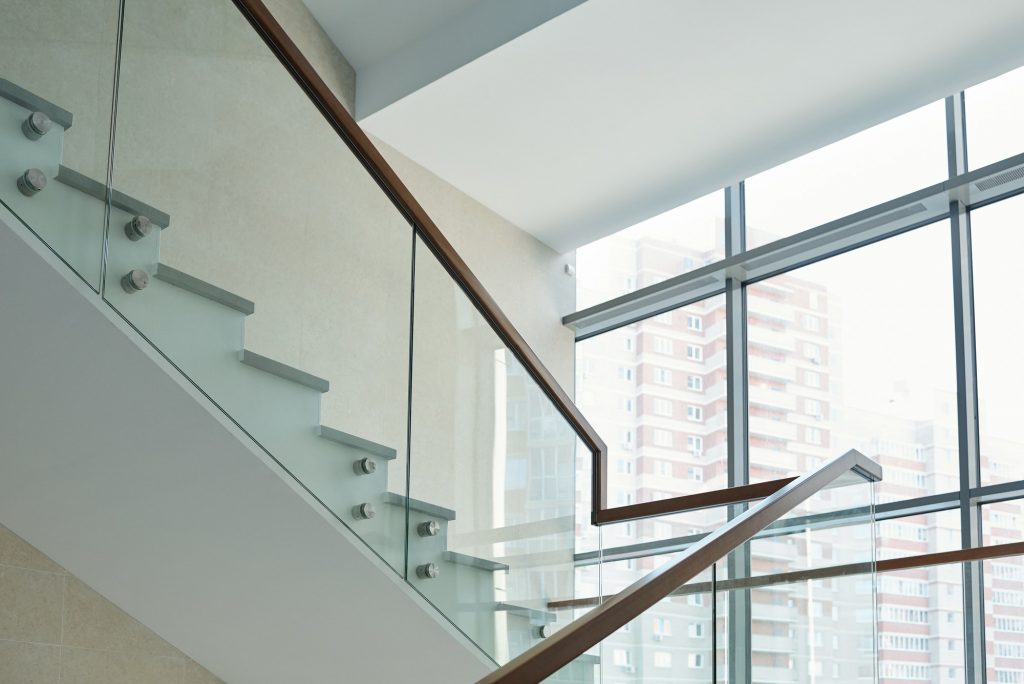 Part of staircase with railings and large window inside new business center